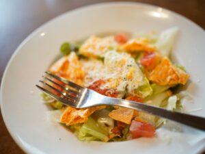 a white plate topped with a salad and a fork